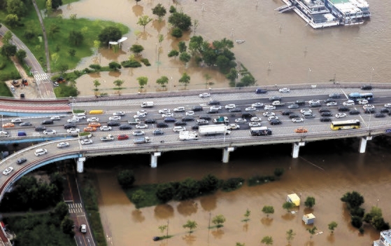 漢江の水位が高まったことを受けて交通規制が敷かれたソウルの各主要道路では、深刻な渋滞が発生した。６日、元暁大橋に帰宅途中の車両が長い列を作っている。