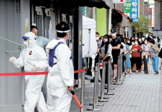 ソウル城北区（ソンブクク）の保健所選別診療所で市民が検査を受けるために列に並んでいる。