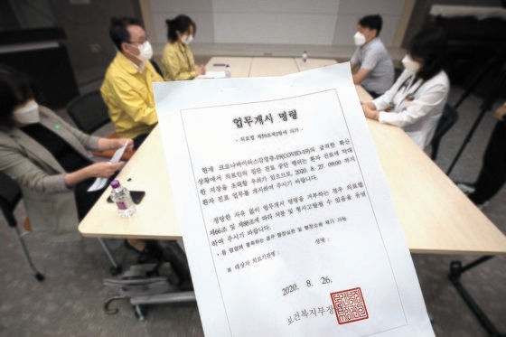 韓国保健福祉部の関係者が２７日、ソウルのある総合病院で医療界の集団休診に関して専任・専攻医の業務開始命令履行状況を点検している。手前は福祉部長官人業務開始命令書。［写真　共同取材団］