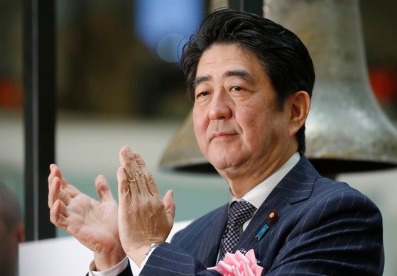 安倍首相が２０１３年１２月３１日に東京証券取引所を訪問し、同年最後の取引を終え拍手している。［中央フォト］