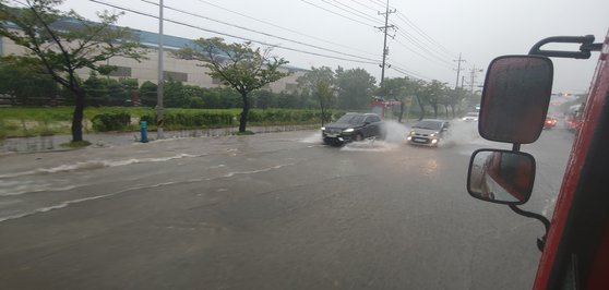 ７日、昌原市熊南洞の韓国鉄鋼前の道路が浸水した。［写真　昌原消防本部］