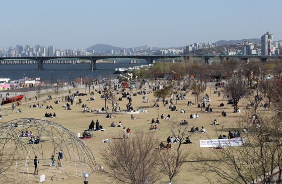 韓国政府が社会的距離強化期間を２週間延長することにした４月４日午後、ソウル・汝矣島漢江公園を訪れた市民が敷物の距離を維持しながら外出を楽しんでいる。キム・ソンリョン記者
