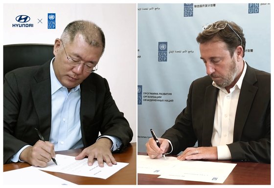 鄭義宣首席副会長（左）とシュタイナー総裁が業務協約に署名している。