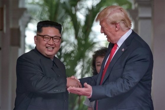 トランプ大統領と金正恩国務委員長が６月１２日、米朝首脳会談が開かれたシンガポールのカペラホテルで握手している。［中央フォト］