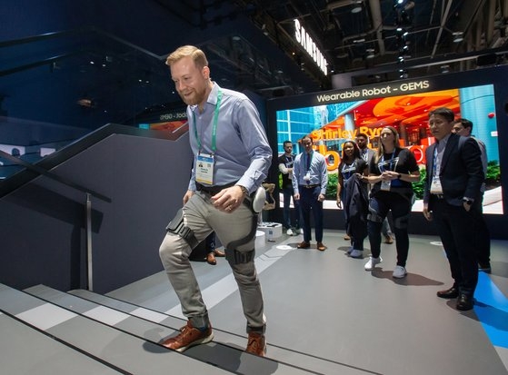 サムスン電子が開発したウェアラブル歩行補助ロボット「ＧＥＭＳ（Ｇａｉｔ　Ｅｎｈａｎｃｉｎｇ　ａｎｄ　Ｍｏｔｉｖａｔｉｎｇ　Ｓｙｓｔｅｍ）Ｈｉｐ」が国内で初めて国際標準「ＩＳＯ　１３４８２」認証を取得した。股関節に着用する身体補助ロボットで、歩行時に２４％ほど力を補助し、歩行速度を１４％高める。写真は今年１月の米ＣＥＳ２０２０で観覧客が「ＧＥＭＳ　Ｈｉｐ」を体験している場面。［写真　サムスン電子］