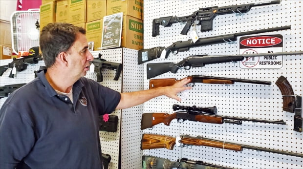 米ワシントン近隣のバージニア州で銃器販売店を経営するブレイナーさんが記者に銃器を説明している。　チュ・ヨンソク特派員