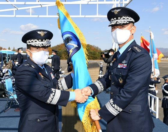李成竜空軍参謀総長が３日に忠州空軍部隊で行われた第３９偵察飛行団創設式で初代偵察飛行団長であるパク・ギワン准将に指揮権の象徴である部隊旗を授けている。［写真　韓国空軍］