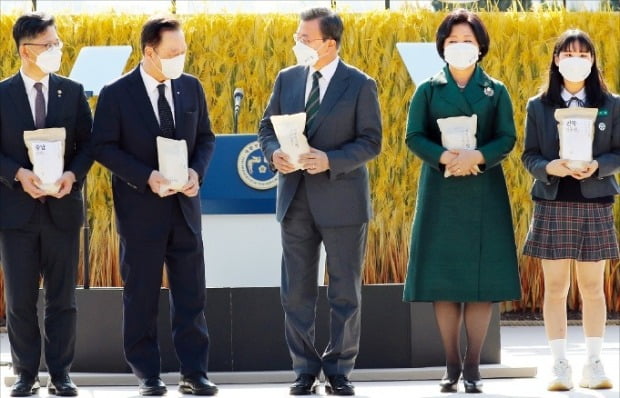 文在寅大統領が１１日に青瓦台で開かれた第２５回農業人の日記念式で各地域を代表するコメで構成された「大韓民国米」を持って記念撮影している。ホ・ムンチャン記者