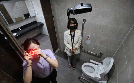 今年７月２０日、大田（テジョン）大徳（テドク）区庁女子トイレに隠しカメラを設置した９級公務員が逮捕された後、区庁関係者が隠しカメラ感知器を使って検査をしている。［ニュース１］