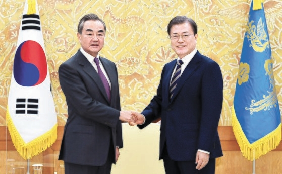韓国の文在寅大統領が２６日午後、青瓦台本館接見室で前日訪韓した中国の王毅外交担当国務委員兼外交部長と会って握手をしている。［写真　青瓦台写真記者団］