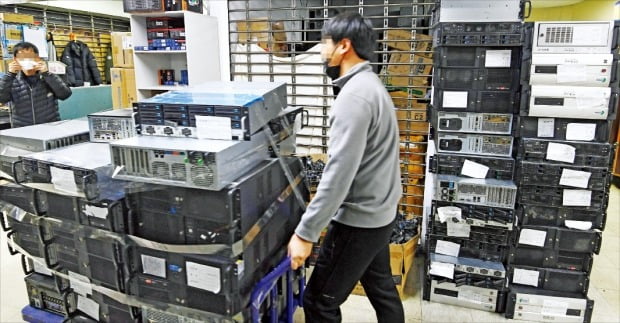 ＜ネットカフェ廃業で貯まる中古ＰＣ＞新型コロナウイルス流行で２～１１月のネットカフェ廃業件数は前年同期比４７．７％急増した。１４日、ソウル・竜山の商店街で商人が積み上げられた中古パソコンを車に運んでいる。カン・ウング記者