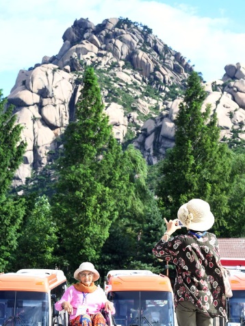 「第２１回離散家族対面行事」で韓国最高齢の対面対象者であるカン・ジョンオクさん（１００）が金剛山の鷹岩を背景に記念写真を撮影している。［写真　共同取材団］