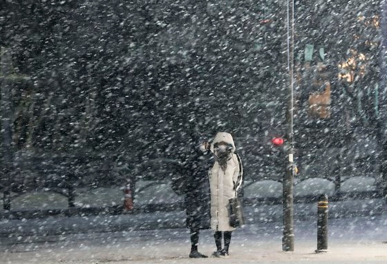 大雪が降った６日午後、仕事帰りの市民がソウル中区（チュング）市庁前の横断歩道を渡っている。キム・ソンニョン記者