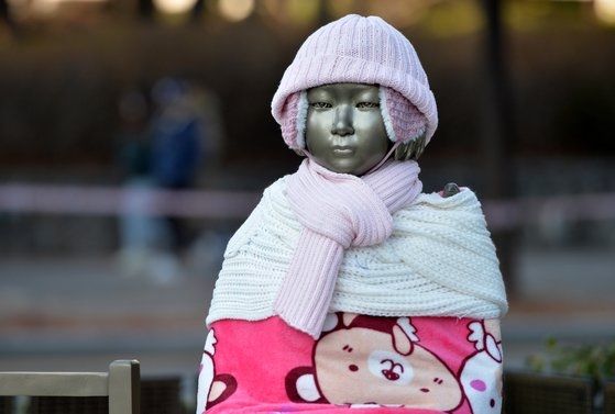 新型コロナウイルス感染症（新型肺炎）が韓国全域に拡大し、厳しい寒さが一日中続いた８日、大田（テジョン）ボラメ公園の平和の少女像にニットの帽子とマフラー、毛布、手袋、靴下などが着せられている。フリーランサー　キム・ソンテ
