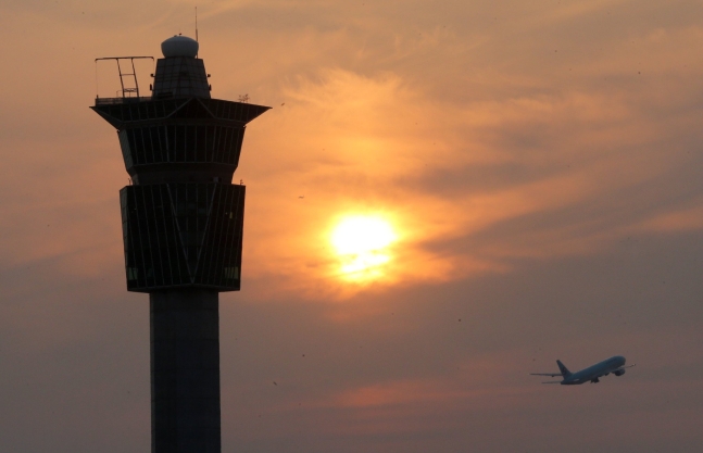 仁川空港の管制塔の横で飛行機が離陸している。［写真　中央日報］