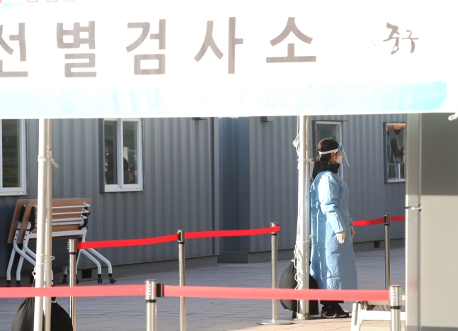 新型肺炎の感染者が韓国で初めて発生して１年目になる２０日、ソウル広場に用意された選別診療所で医療スタッフが柱にもたれて休憩している。［中央フォト］
