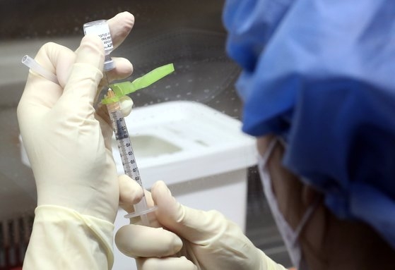 ２７日午前、ソウル中区（チュング）国立中央医療院中央予防接種センターで医療スタッフが新型肺炎のファイザーワクチンを小分して接種を準備している。［写真　共同取材団］