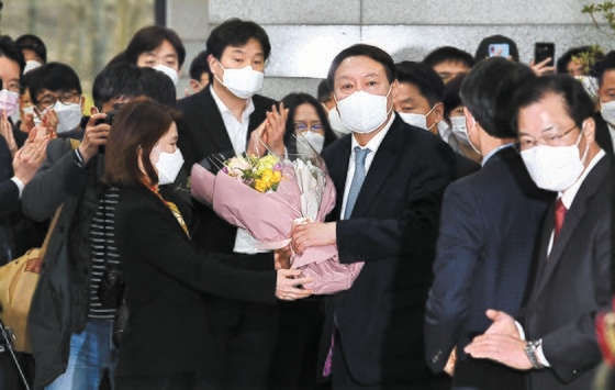 辞意を表明した尹錫悦（ユン・ソクヨル）検察総長が４日午後、ソウル瑞草区（ソチョグ）大検察庁ロビーで職員と挨拶を交わした後、花束を持って庁舎を離れている。キム・ギョンロク記者