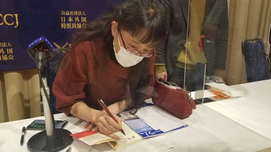 小説『ＪＲ上野駅公園口』で全米図書賞を受賞した在日韓国人作家の柳美里氏が２月２５日、外国特派員協会（ＦＣＣＪ）で主催した記者会見後、著書にサインをしている。ユン・ソルヨン特派員