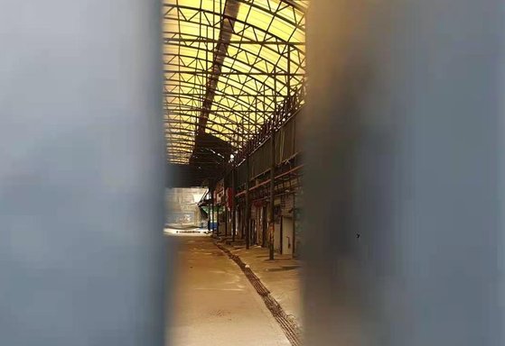 新型コロナウイルス最初の発源地だった武漢華南水産物市場。フェンスでふさがれた隙間から閉店した店舗の荒涼とした姿が見られる。パク・ソンフン特派員