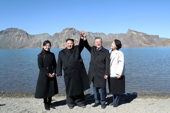 韓国の文在寅（ムン・ジェイン）大統領（右から２人目）と金正淑（キム・ジョンスク）夫人（右から１人目）、北朝鮮の金正恩（キム・ジョンウン）国務委員長（左から１人目）と李雪主（リ・ソルジュ）夫人（左から１人目）が２０１８年９月、白頭山（ペクドゥサン）天地に立って記念撮影に臨んでいる。［平壌（ピョンヤン）写真共同取材団］