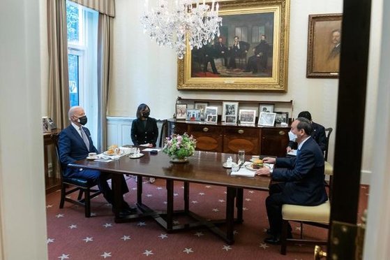 １６日、米国のジョー・バイデン大統領（左）と菅義偉首相（右）が米ホワイトハウスで昼食にハンバーガーを食べながら会談している。［写真　ツイッター　キャプチャー］