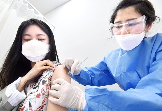 韓国では医療サービス業従事者や航空乗務員を対象にした新型コロナウイルス感染症（新型肺炎）ワクチン接種が始まった。１９日、ソウル江西区（カンソグ）のある病院で乗務員がアストラゼネカ（ＡＺ）ワクチンの接種を受けている。［写真　ニューシス］