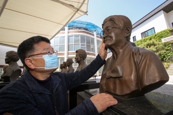 今月２日、京畿道広州市退村面（キョンギド・クァンジュシ・テチョンミョン）の福祉施設「ナヌムの家」を訪れた故イ・ヨンニョさんの息子ソ・ビョンファさんがヨンニョさんの胸像の顔に触れている。ウ・サンジョ記者