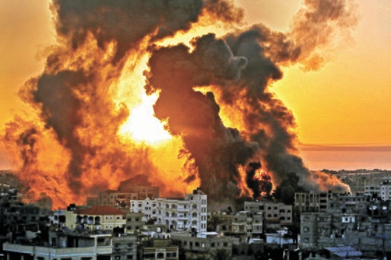１２日、イスラエル軍の空襲を受け、パレスチナ自治区ガザで黒い煙が上がっている。