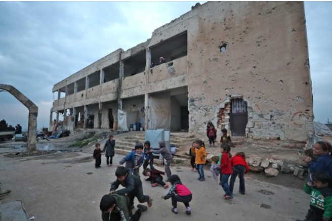 毀損された学校建物の前で走り回って遊んでいるシリアの子どもたち。［写真　ＡＦＰ＝聯合ニュース］