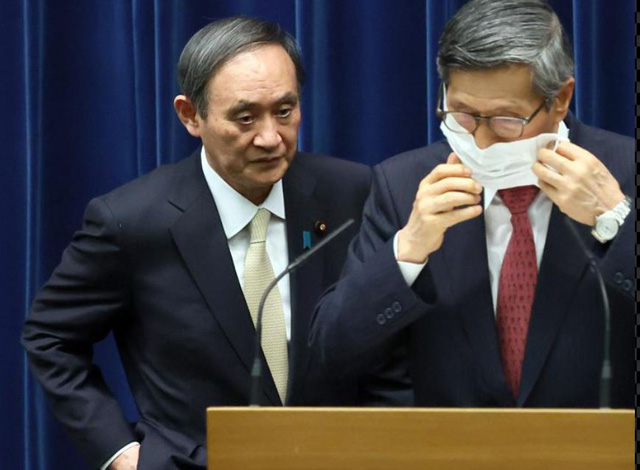 マスクに触れる尾身会長を見つめる菅首相。［写真　ＡＦＰ＝ニュース１］