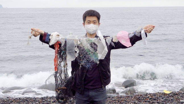 記者が巨済島（コジェド）の海辺のプラスチックごみを見せている。　ワン・ジュンヨルＰＤ