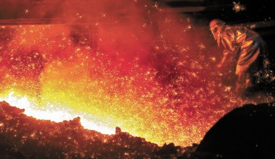 ポスコ浦項製鉄所第１高炉で従業員が高炉からあふれる黄金色の銑鉄を取り出す作業をしている。［写真　ポスコ］