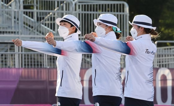 アーチェリー韓国代表のアン・サン、チャン・ミンヒ、カン・チェヨンが２５日、東京夢の島公園で行われた東京五輪女子アーチェリー団体の表彰式で金メダルパフォーマンスをしている。　東京＝写真共同取材団