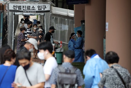 韓国では１１日午前０時基準で新型コロナウイルス感染症（新型肺炎）の感染者数が歴代最大となる２２２３人を記録した。この日、市民がソウル冠岳区（クァナクク）保健所に準備された新型コロナ選別診療所で検査を受けるため待機している。キム・ギョンロク記者