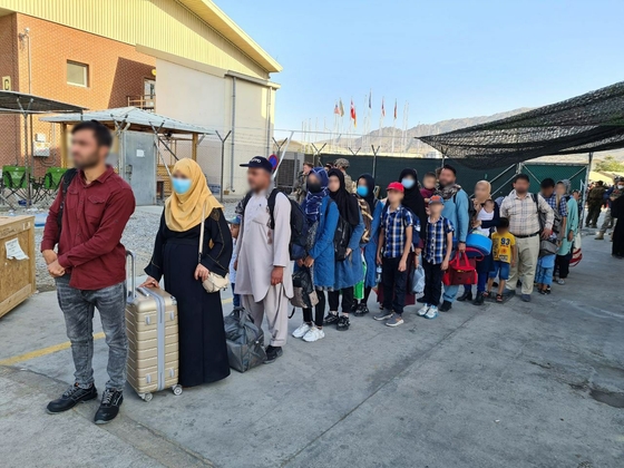 韓国外交部はその間、アフガニスタンで韓国政府の活動を支援してきた現地人職員、そして配偶者、未成年の子ども、両親など３８０人余りが２６日国内に到着すると２５日、伝えた。韓国に入国するアフガン人が身元確認を終えた後、韓国空軍輸送機の搭乗を待っている。［写真　外交部］