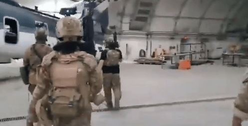 タリバン軍が米軍が残していったと推定される軍用ＣＨ－４７チヌークヘリコプター側に近づいている（写真　タリブタイムス）