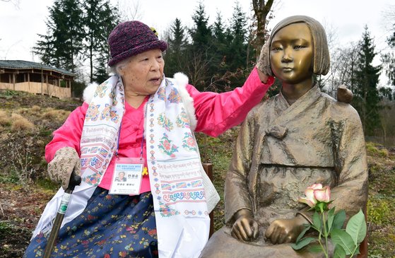 旧日本軍慰安婦被害者の故アン・チョムスンさんが独レーゲンスブルク付近ヴィーゼントのネパール－ヒマラヤパビリオン公園に設置された平和の少女像に触れている。　［写真提供＝水原市］