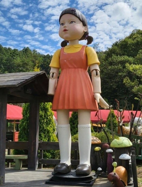Ｎｅｔｆｌｉｘ（ネットフリックス）ドラマ『イカゲーム』で最初の鬼ごっこゲームの鬼人形として登場した別名「ヨンヒ人形」がドラマ撮影が終わった後、忠清北道鎮川（チュンチョンブクド・ジンチョン）のある博物館に保管されていることが確認された。あるオンライン掲示板に投稿された鎮川馬車博物館体験村に立っているヨンヒ人形。この人形は２７日から非公開となっている。［写真　オンライン　コミュニティ　キャプチャー］