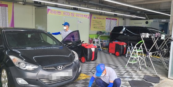 龍仁市「エコスチーム洗車場　孝（ヒョ）」で７０代以上の従業員が洗浄している。チェ・ヘソン記者