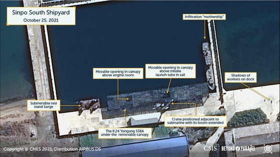 米国戦略国際問題研究所（ＣＳＩＳ）はコリアチェアのツイッターアカウントを通じ、２５日に新浦基地を撮影した衛星写真を翌日公開した。写真には覆いで遮られた「８．２４英雄艦」と潜水艦ミサイル発射管入口に向けてブームを伸ばした起重機が捉えられた。［ＣＳＩＳコリアチェア　ツイッターキャプチャー］
