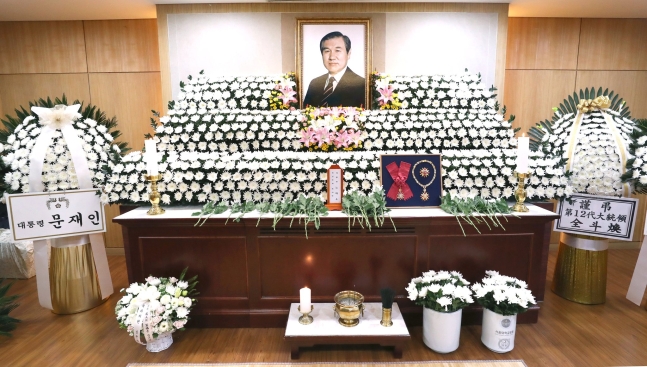 ２７日にソウル大学病院の葬儀場に設けられた第１３代大統領を務めた盧泰愚氏の葬儀式場。左側には文在寅大統領からの弔花が、右側には第１２代大統領を務めた全斗煥氏の弔花が置かれている。［写真　共同取材団］