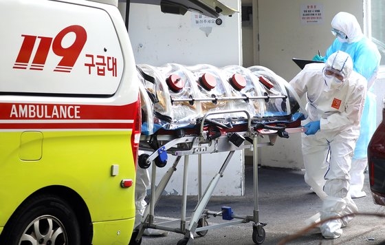 昨年集団感染（クラスター）が発生した釜山（プサン）ある療養病院患者が救急車を利用して隔離病院に移送されている。［写真　中央フォト］