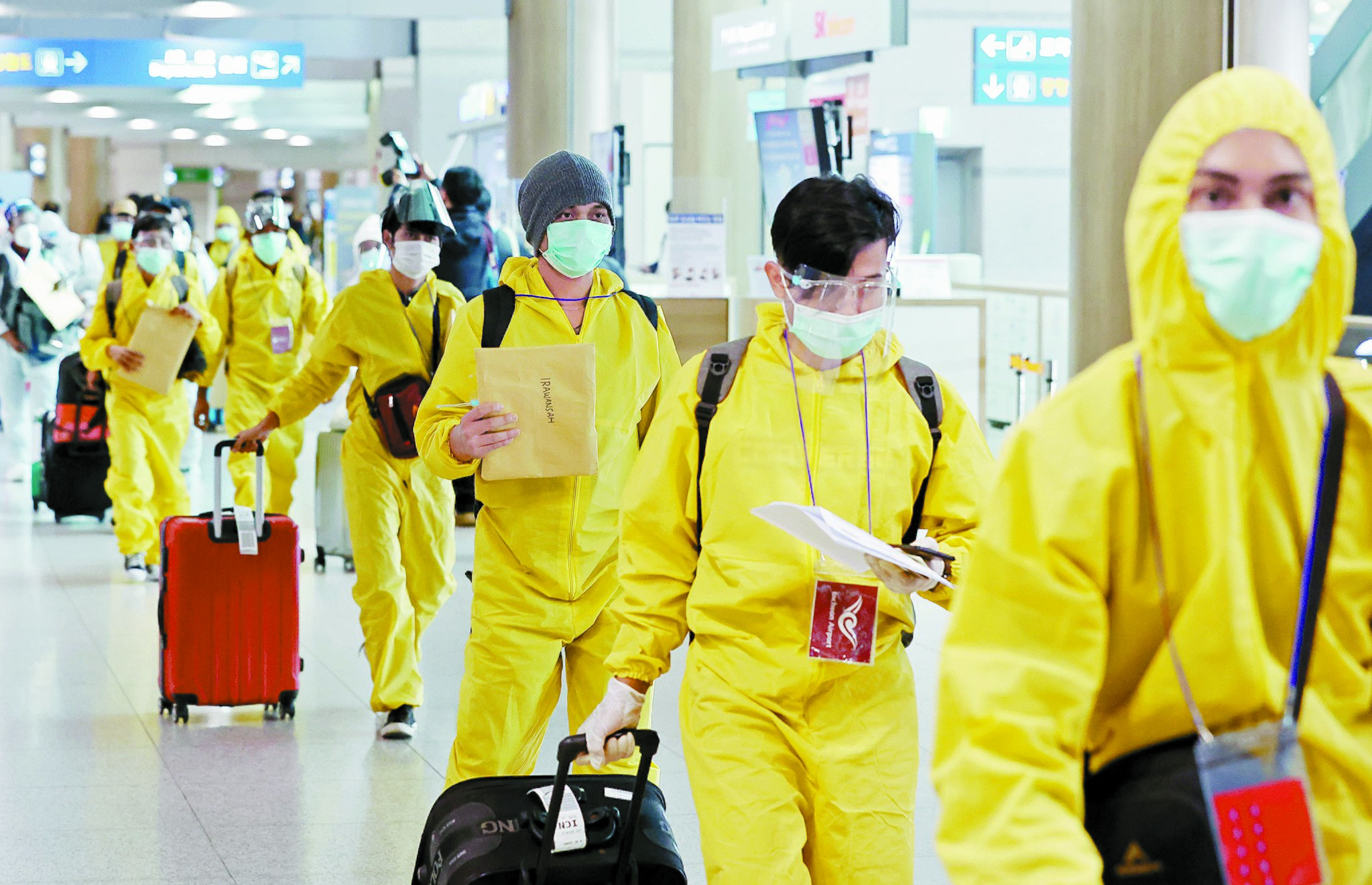 ２９日午前、仁川（インチョン）国際空港第１旅客ターミナルで、防護服とフェイスシールドを着用した海外入国者が移動している。　［ニュース１］