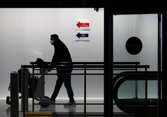 １１月３０日、マスクをして成田空港に入る外国人。［写真　ロイター＝聯合ニュース］