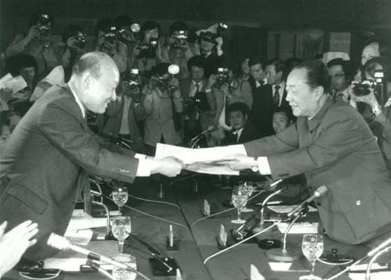 韓国の孔魯明（コン・ノミョン）当時外務部次官補（左）が１９８３年５月、中国民航機韓国着陸事件を解決し、中国側交渉団の沈図代表と合意文書を交換している。［写真　孔魯明］