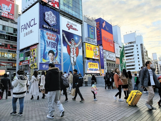 新型コロナウイルスの感染拡大が鈍化した日本・大阪の観光名所道頓堀通りは人々で活気を帯びている。日本では社会的距離確保が緩和され年末年始の会合が増えた。［写真　成川彩］