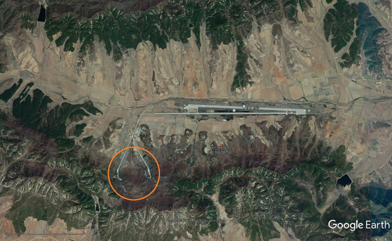 黄海南道苔灘郡の北朝鮮の苔灘（テタン）飛行場（空軍基地）。北朝鮮は外部の攻撃を遮断するため山の中に東西に滑走路を建設し、滑走路付近の山の地下に格納施設を置いている。山の地下の格納施設の両側に出入口がある。　［写真＝グーグルアース］