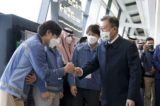 中東３カ国を歴訪中の文在寅大統領が１９日にサウジアラビアのリヤドで地下鉄建設現場を訪問し、サムスン物産の関係者らとグータッチをしている。［写真　青瓦台写真記者団］