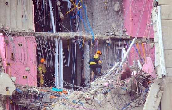 ２６日、光州の新築マンション崩壊事故現場で救助隊員が崩壊が止まった地点である２２階など上層部を中心にコンクリート片と鉄筋などの残骸を片づけて行方不明者を探している。フリーランサー　チャン・ジョンピル